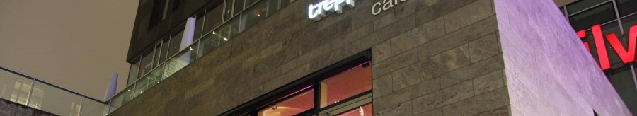 Modern building with the inscription 'treppe café - bar' and illuminated windows at night., © Café Treppe, Stuttgart