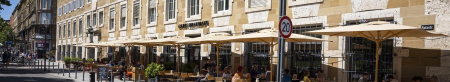 Carls Brauhaus with street café, parasols and guests on a busy street in sunny weather., © SMG Stuttgart Marketing GmbH - Sarah Schmid
