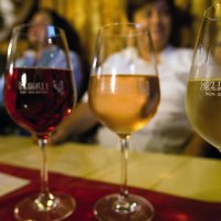 Vier Weingläser mit unterschiedlichen Weinsorten stehen auf einem Tisch. Im Hintergrund sind unscharf Personen zu erkennen., © Stuttgart-Marketing GmbH