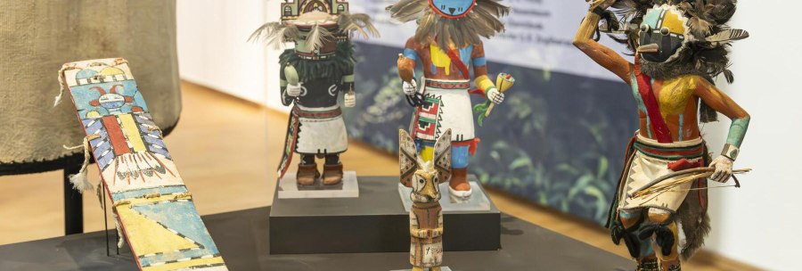Traditional, colorful figures and masks exhibited in the Linden-Museum Stuttgart, arranged on a table., &copy; SMG Stuttgart Marketing GmbH - Sarah Schmid