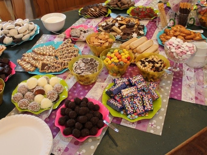 A table is covered with a variety of sweets and cookies, including gingerbread, chocolate and colorful candies, arranged on colorful plates., &copy; Cool-Tours StattReisen