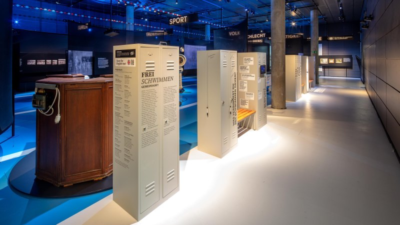 Free Swimming' exhibition at the Haus der Geschichte Baden-W&uuml;rttemberg with illuminated lockers and a blue atmosphere., &copy; HdGBW/ Daniel Stauch