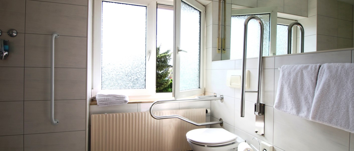 Barrier-free bathroom with grab rails, floor-level shower, open window and towels. Suitable for guests with reduced mobility., © TOMAS Barrier-free bathroom with grab rails, floor-level shower, open window and towels. Suitable for guests with reduced mobility., © TOMAS