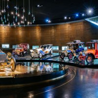 Historische Autos in einer Ausstellung im Mercedes-Benz Museum, beleuchtet unter einer Decke mit hängenden Glaskugeln., © Stuttgart-Marketing GmbH, Thomas Niedermüller