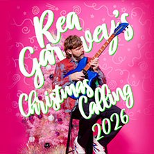 A man with a guitar sits in front of a pink background with a Christmas tree. The text 'Rea Garvey's Christmas Calling 2026' is prominently displayed., © links im Bild A man with a guitar sits in front of a pink background with a Christmas tree. The text 'Rea Garvey's Christmas Calling 2026' is prominently displayed., © links im Bild