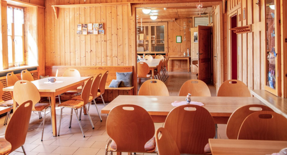 Wood-paneled room with several tables and chairs, window on the left, cozy atmosphere., &copy; DJH Baden-W&uuml;rttemberg e.V.
