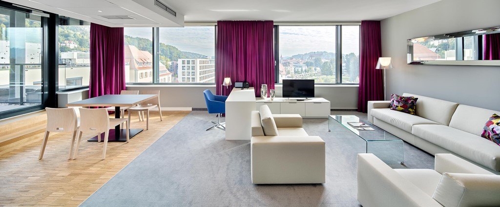 Modern apartment with white furniture, purple curtains and large windows with city views., © Hotel am Remspark Modern apartment with white furniture, purple curtains and large windows with city views., © Hotel am Remspark