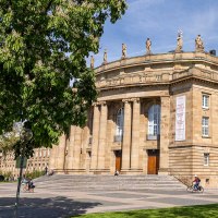 The Stuttgart State Opera in sunny weather, surrounded by green trees and a cyclist in the foreground., &copy; Stuttgart Marketing GmbH, Sarah Schmid