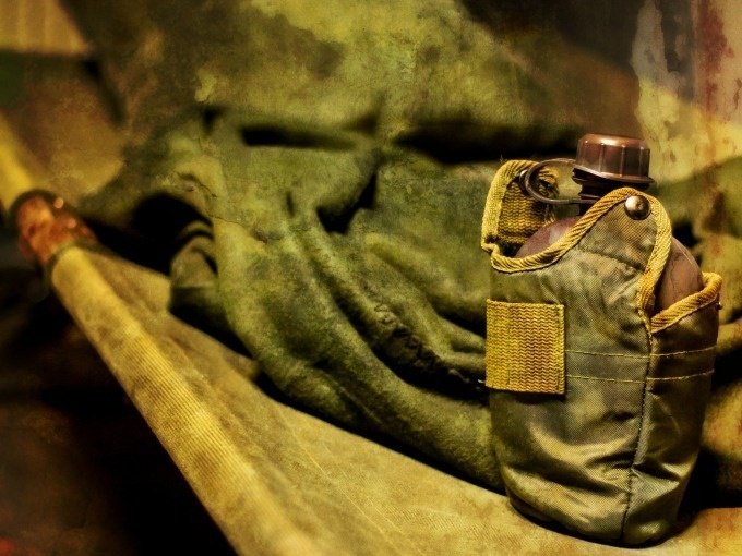 A green canteen lies on an olive green military couch, surrounded by a rustic, worn background., © ExitGames Stuttgart A green canteen lies on an olive green military couch, surrounded by a rustic, worn background., © ExitGames Stuttgart