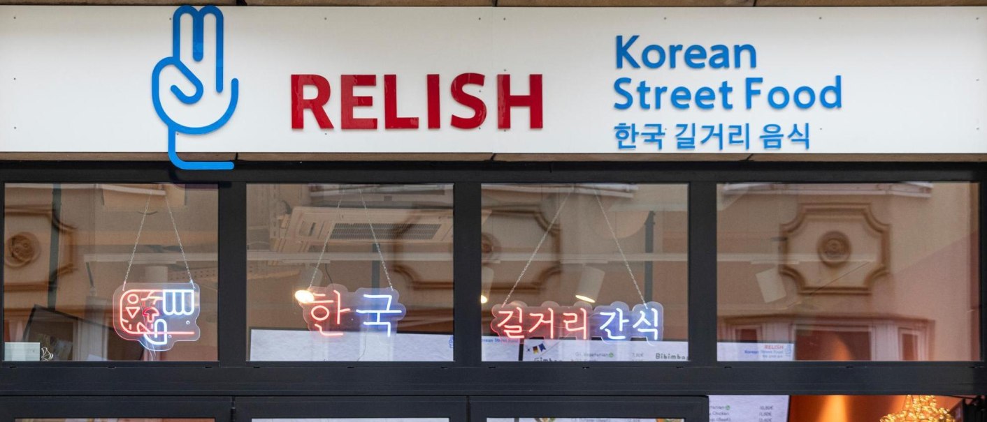 Entrance to a restaurant with the sign 'Relish Korean Street Food' and Korean characters. Neon lights in the window., &copy; Stuttgart-Marketing GmbH, Sarah Schmid