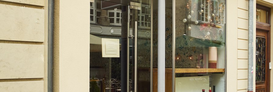 Entrance to a store with the sign 'Stadtbesen'. There are bottles of wine in the display case. A red neon sign is attached to the wall., &copy; Stuttgart-Marketing GmbH, Sarah Schmid