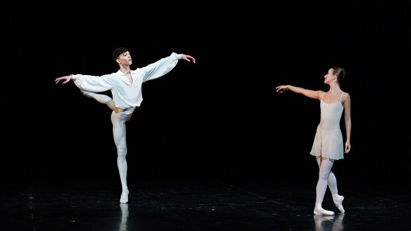 Two ballet dancers on stage, one in a white shirt and the other in a cream-colored dress, strike an elegant pose., &copy; W&uuml;rttembergische Staatstheater Stuttgart