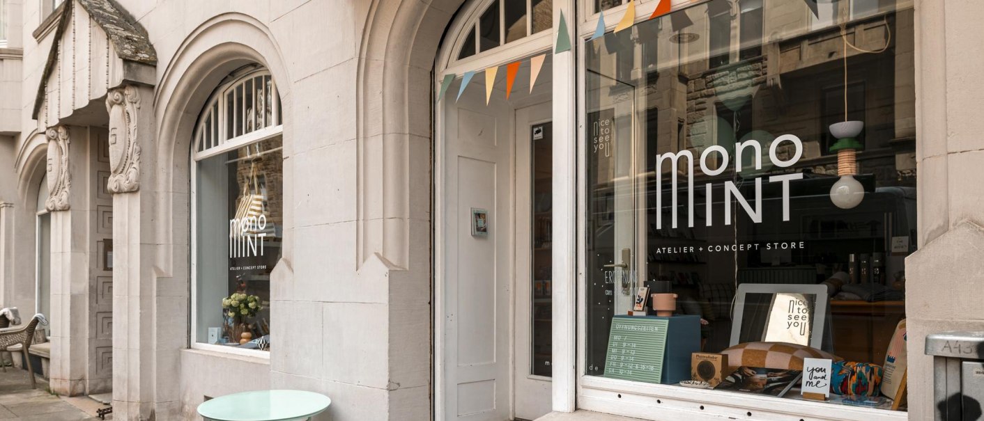 Eingang des Monomint Concept Stores mit dekorativem Schaufenster und bunter Wimpelkette., © SMG, Sarah Schmid