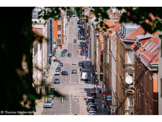 Blick auf eine belebte Stra&szlig;e in Stuttgart mit Autos und historischen Geb&auml;uden. Die Stra&szlig;e ist von B&auml;umen umrahmt., &copy; Stuttgart Marketing GmbH
