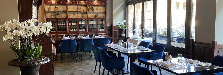 Elegantes Restaurant mit blauen Stühlen, Holzboden und großen Fenstern. Orchideen und eine Vitrine mit Flaschen schmücken den Raum., © Steigenberger Hotels GmbH Elegantes Restaurant mit blauen Stühlen, Holzboden und großen Fenstern. Orchideen und eine Vitrine mit Flaschen schmücken den Raum., © Steigenberger Hotels GmbH