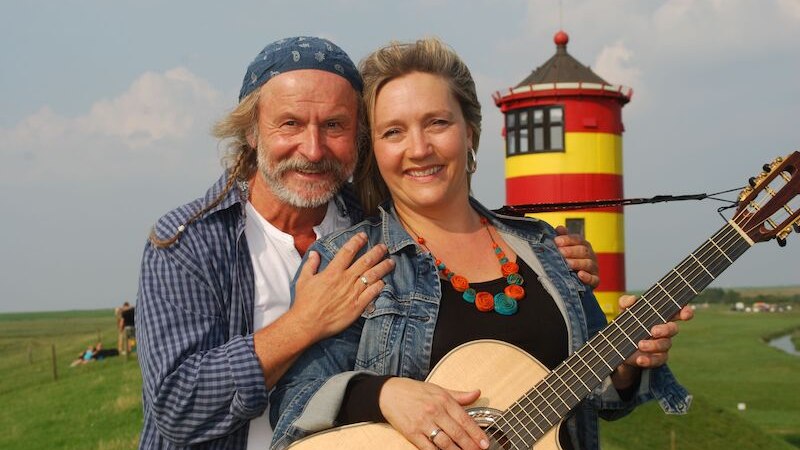 Ein Mann und eine Frau mit Gitarre lächeln vor dem Pilsumer Leuchtturm in die Kamera., © Börsenverein des Deutschen Buchhandels, Landesverband Baden-Württemberg e.V. Ein Mann und eine Frau mit Gitarre lächeln vor dem Pilsumer Leuchtturm in die Kamera., © Börsenverein des Deutschen Buchhandels, Landesverband Baden-Württemberg e.V.