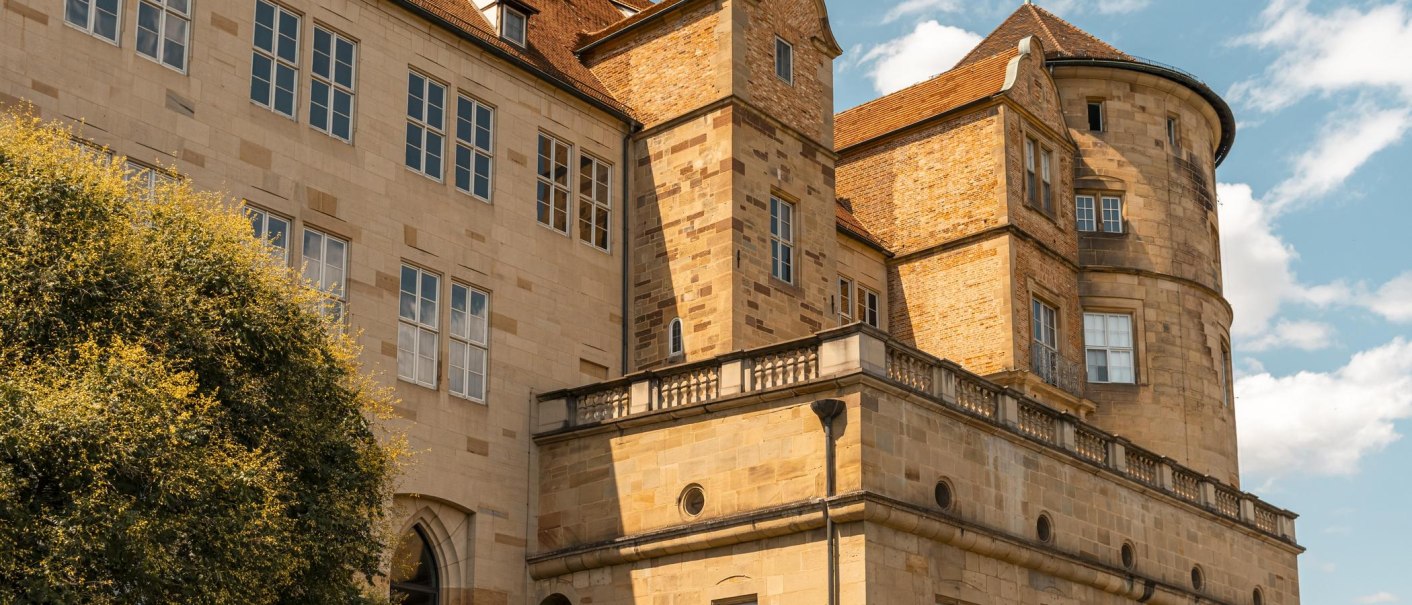 Ein altes Schloss mit markanten Türmen und vielen Fenstern, umgeben von einem blauen Himmel und einigen Wolken., © Stuttgart-Marketing GmbH, Sarah Schmid Ein altes Schloss mit markanten Türmen und vielen Fenstern, umgeben von einem blauen Himmel und einigen Wolken., © Stuttgart-Marketing GmbH, Sarah Schmid