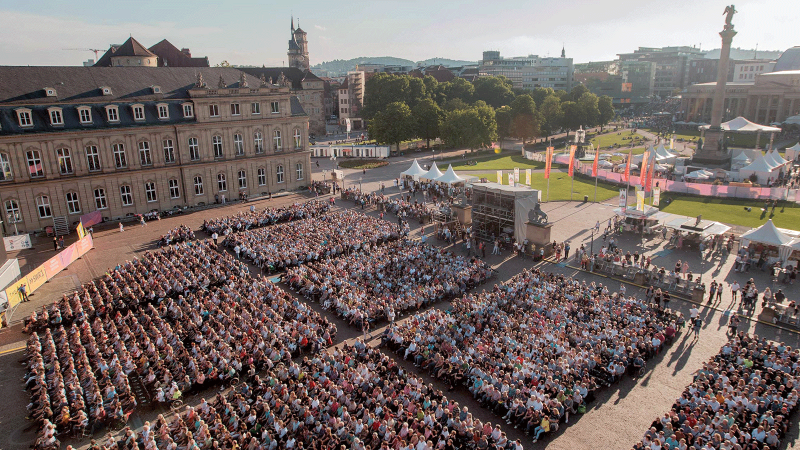 Luftaufnahme des SWR Sommerfestivals auf dem Schlossplatz Stuttgart. Viele Menschen sitzen vor einer Bühne, umgeben von historischen Gebäuden und Grünflächen., © SWR, Markus Palmer Luftaufnahme des SWR Sommerfestivals auf dem Schlossplatz Stuttgart. Viele Menschen sitzen vor einer Bühne, umgeben von historischen Gebäuden und Grünflächen., © SWR, Markus Palmer