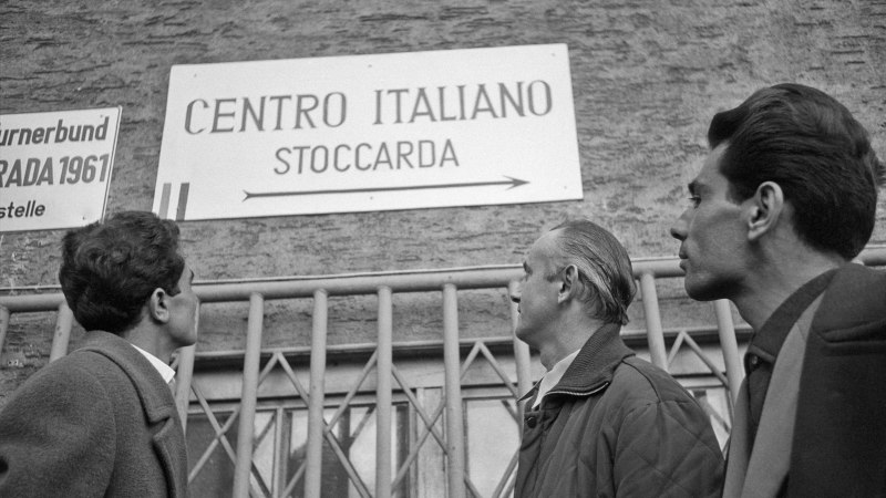Drei M&auml;nner betrachten ein Schild mit der Aufschrift 'Centro Italiano Stoccarda'. Es scheint sich um ein italienisches Zentrum in Stuttgart zu handeln., &copy; Landesarchiv Baden-W&uuml;rttemberg HStAS Q 2-50_Nr 1137_[68]