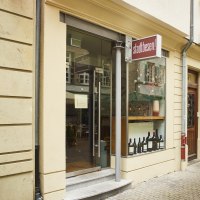 Entrance to a store with the sign 'Stadtbesen'. There are bottles of wine in the display case. A red neon sign is attached to the wall., &copy; Stuttgart-Marketing GmbH, Sarah Schmid