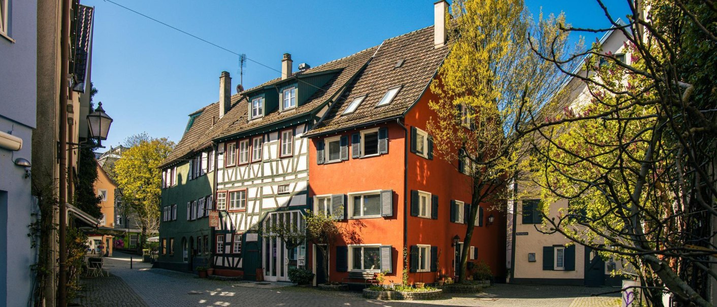 Half-timbered houses in the old town of Schorndorf, surrounded by trees and a blue sky. The buildings are brightly painted and gleam in the sunlight., © Stuttgart-Marketing GmbH, Sarah Schmid Half-timbered houses in the old town of Schorndorf, surrounded by trees and a blue sky. The buildings are brightly painted and gleam in the sunlight., © Stuttgart-Marketing GmbH, Sarah Schmid