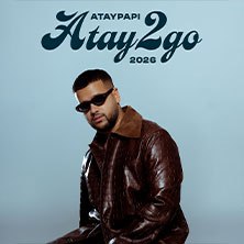 Ein Mann in brauner Lederjacke und Sonnenbrille sitzt vor einem blauen Hintergrund. Oben steht 'Ataypapi Atay2go 2026'., © links im Bild Ein Mann in brauner Lederjacke und Sonnenbrille sitzt vor einem blauen Hintergrund. Oben steht 'Ataypapi Atay2go 2026'., © links im Bild