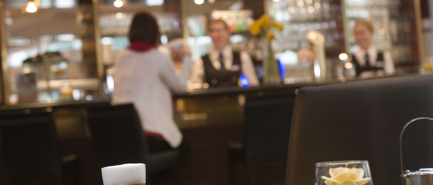 Ein Tisch in einem Café mit Kaffee, Wasser und Gebäck. Im Hintergrund eine Theke mit Bedienung und der Schriftzug 'Café Espresso'., © Maritim Hotelgesellschaft mbH Ein Tisch in einem Café mit Kaffee, Wasser und Gebäck. Im Hintergrund eine Theke mit Bedienung und der Schriftzug 'Café Espresso'., © Maritim Hotelgesellschaft mbH