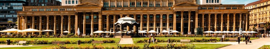 The K&ouml;nigsbau in Stuttgart with its classicist fa&ccedil;ade and glass roof, surrounded by green spaces and walkers in sunny weather., &copy; Stuttgart-Marketing GmbH, Sarah Schmid