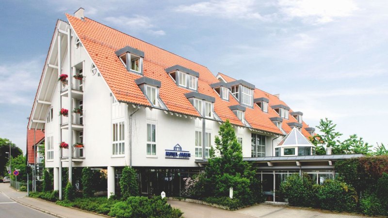 Modernes Hotel mit roten Ziegeld&auml;chern und wei&szlig;en W&auml;nden, umgeben von B&auml;umen und Pflanzen, an einer Stra&szlig;e gelegen., &copy; Hotel Alber KG