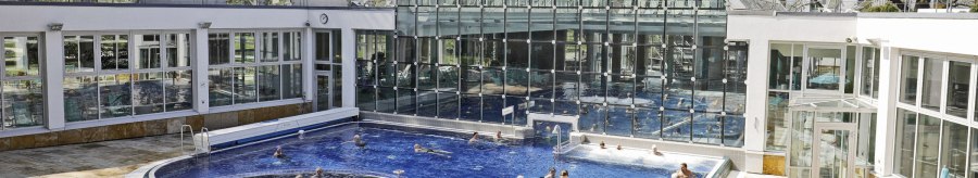 Das SoleBad Bad Cannstatt zeigt ein modernes Schwimmbecken mit Glasfassade. Menschen entspannen im Wasser und auf Liegest&uuml;hlen., &copy; Stuttgarter B&auml;der