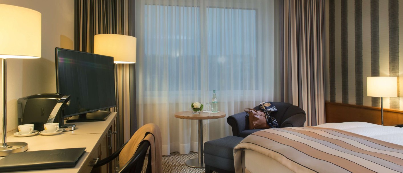 Modern hotel room with double bed, desk, TV and cozy lighting. Curtains and carpet complete the stylish ambience., © Maritim Hotelgesellschaft mbH Modern hotel room with double bed, desk, TV and cozy lighting. Curtains and carpet complete the stylish ambience., © Maritim Hotelgesellschaft mbH