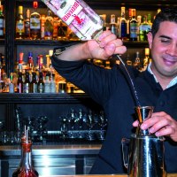 A bartender pours gin into a jigger. Numerous bottles can be seen on a shelf in the background., &copy; &copy; TMBW, Gregor Lengler