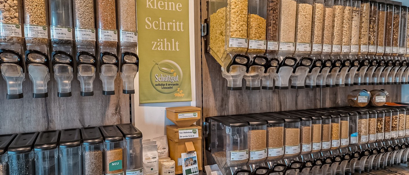 Schüttgutspender in einem Unverpackt-Laden mit verschiedenen Lebensmitteln. Ein Schild sagt: "Jeder kleine Schritt zählt"., © Schüttgut, Stuttgart Schüttgutspender in einem Unverpackt-Laden mit verschiedenen Lebensmitteln. Ein Schild sagt: "Jeder kleine Schritt zählt"., © Schüttgut, Stuttgart