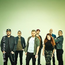 Sieben Personen posieren in legerer Kleidung vor einem neutralen Hintergrund. Die Gruppe wirkt entspannt und selbstbewusst., © links im Bild Sieben Personen posieren in legerer Kleidung vor einem neutralen Hintergrund. Die Gruppe wirkt entspannt und selbstbewusst., © links im Bild