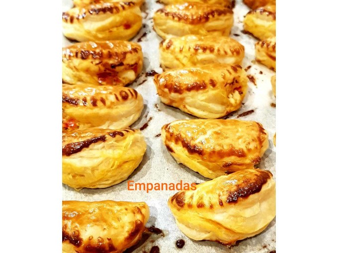 Golden-brown empanadas on a baking tray, freshly baked and shiny. The word "Empanadas" can be seen in the picture., &copy; Kultweine-Kochwelten-Kunst&uuml;cke - Kochschule Sonja Lenz