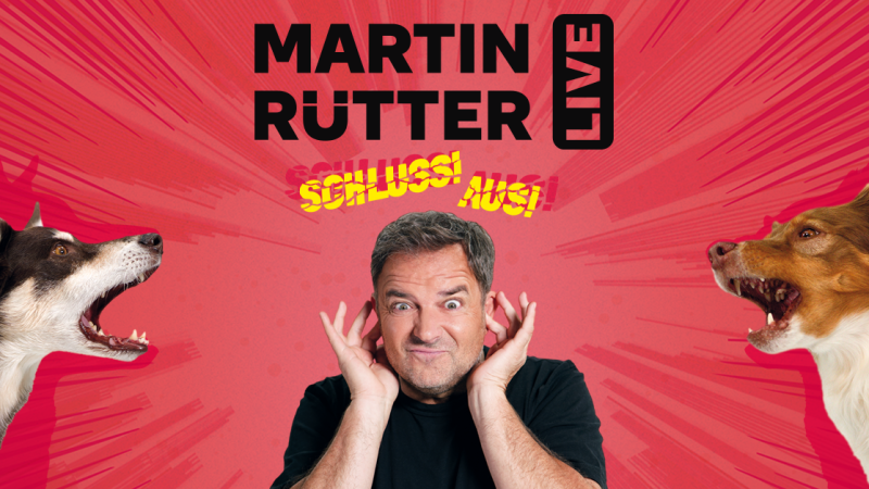Ein Mann h&auml;lt sich die Ohren zu, w&auml;hrend zwei Hunde auf ihn zu bellen scheinen. Der Text 'Martin R&uuml;tter Live - Schluss! Aus!' ist auf rotem Hintergrund zu sehen., &copy; links im Bild