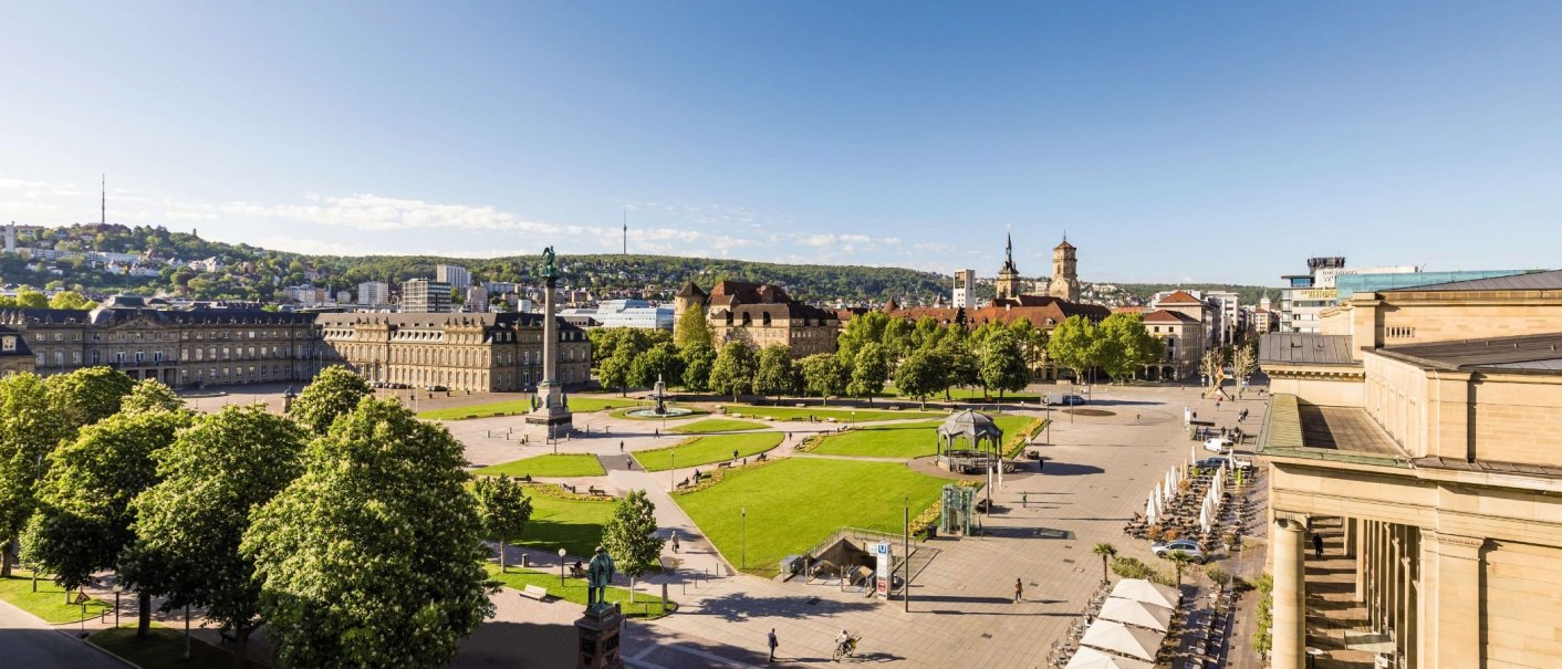 Panoramablick auf den Schlossplatz in Stuttgart mit Grünflächen, historischen Gebäuden und einem klaren blauen Himmel., © Stuttgart-Marketing GmbH Werner Dieterich