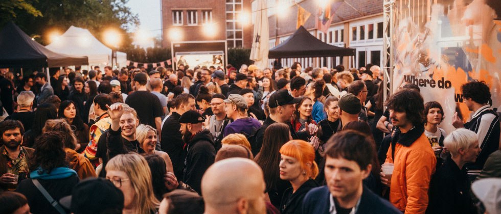 Gro&szlig;e Menschenmenge bei einem Outdoor-Event mit festlicher Beleuchtung und verschiedenen St&auml;nden im Hintergrund., &copy; Ilkay Karakurt