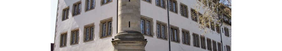 Die Alte Kanzlei in Stuttgart, ein historisches Gebäude mit vielen Fenstern, einem markanten Eckpfeiler und einem Außenbereich mit Sonnenschirmen., © Stuttgart-Marketing GmbH