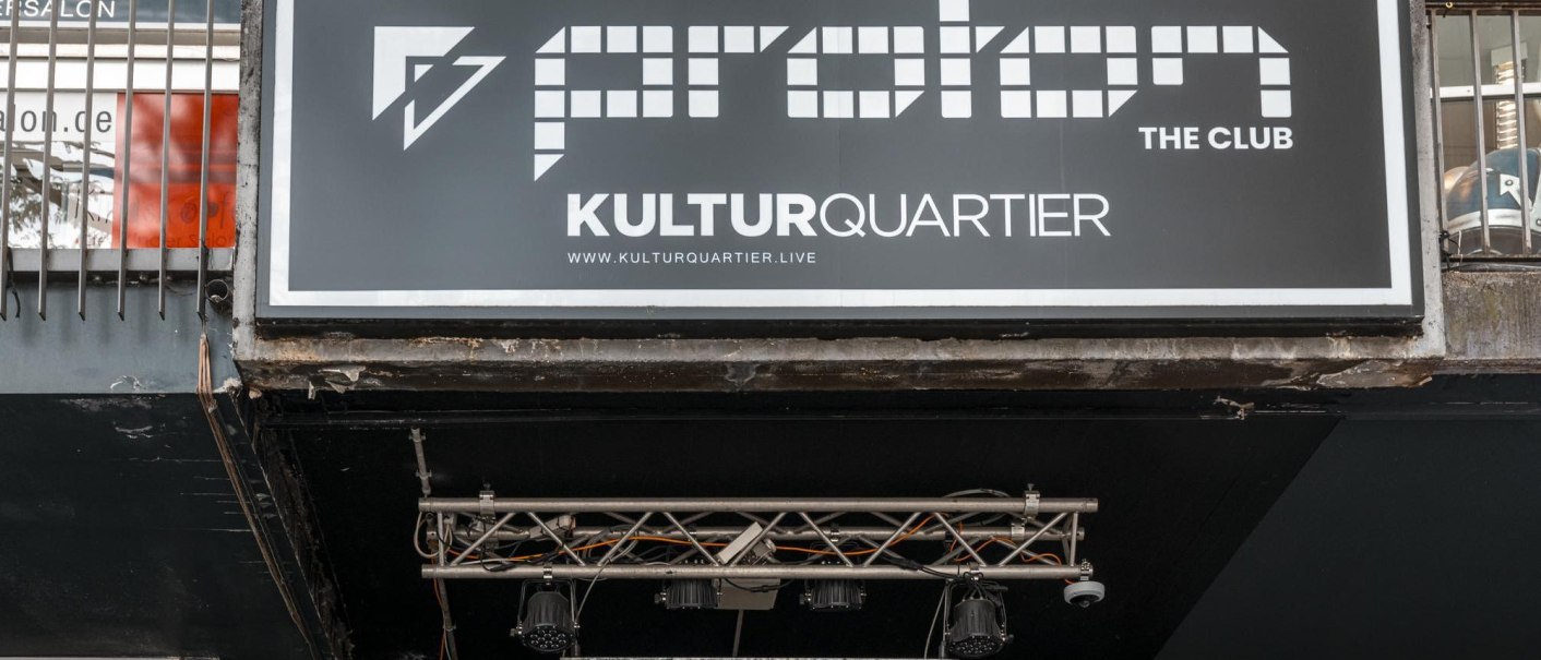 Schild von Proton The Club im Kulturquartier mit Website-Adresse. Darunter Beleuchtung und Metallstruktur sichtbar., © Stuttgart Marketing GmbH, Sarah Schmid