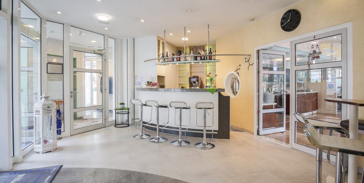 Moderne Hotelbar mit wei&szlig;en Barhockern, einer Theke mit Flaschen und Gl&auml;sern. Glast&uuml;ren f&uuml;hren zu einem weiteren Raum. Helle, einladende Atmosph&auml;re., &copy; TOMAS