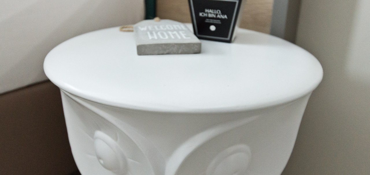 Ein wei&szlig;er Nachttisch mit einer "Welcome Home"-Deko und einer kleinen Schachtel mit der Aufschrift "Hallo, ich bin Ana"., &copy; Arthotel Ana / elaya