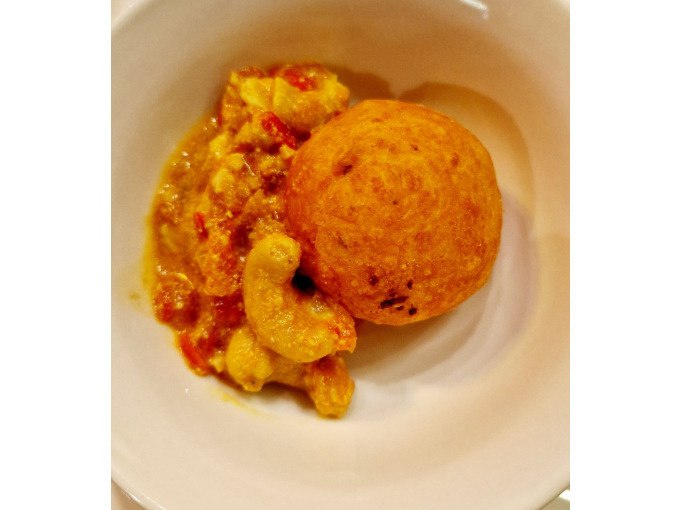 Ein Teller mit einem frittierten Ball und einer cremigen, gelben Soße mit Gemüse. Das Gericht ist Teil eines indischen Kochkurses., © Kultweine-Kochwelten-Kunstücke - Kochschule Sonja Lenz Ein Teller mit einem frittierten Ball und einer cremigen, gelben Soße mit Gemüse. Das Gericht ist Teil eines indischen Kochkurses., © Kultweine-Kochwelten-Kunstücke - Kochschule Sonja Lenz