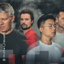 Vier Personen stehen vor einem dunklen Hintergrund, teilweise in Rauch geh&uuml;llt. Sie tragen l&auml;ssige Kleidung., &copy; links im Bild