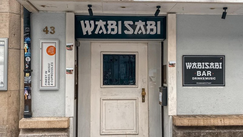 Außenansicht der Wabisabi Bar mit Eingangstür, Schildern und der Hausnummer 43. Die Bar bietet Drinks, Musik und Cup Noodles an., © SMG Außenansicht der Wabisabi Bar mit Eingangstür, Schildern und der Hausnummer 43. Die Bar bietet Drinks, Musik und Cup Noodles an., © SMG
