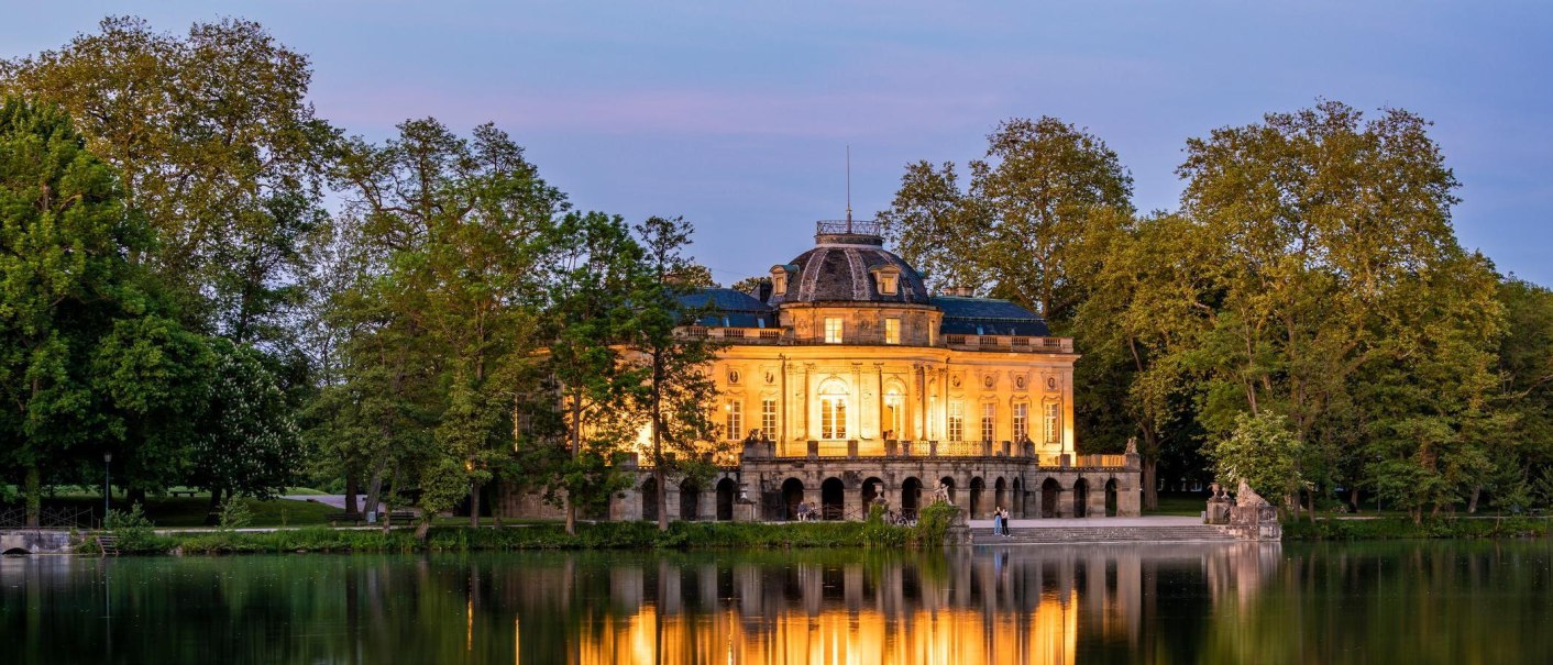 At night, the illuminated Monrepos Castle is reflected in the calm lake, surrounded by lush trees., &copy; &copy; Stuttgart-Marketing GmbH, Werner Dieterich