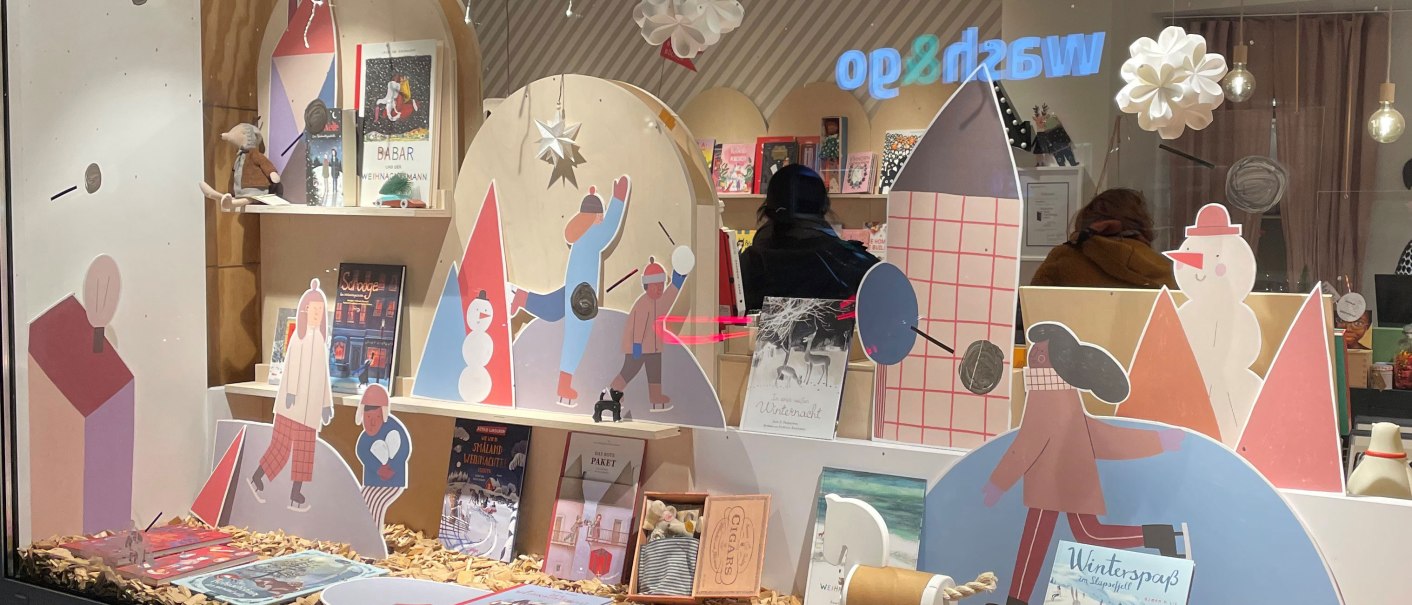 Ein Schaufenster mit winterlicher Dekoration, Kinderb&uuml;chern und Pappfiguren. Lichterketten und Schneeflocken h&auml;ngen von der Decke., &copy; Stuttgart-Marketing GmbH