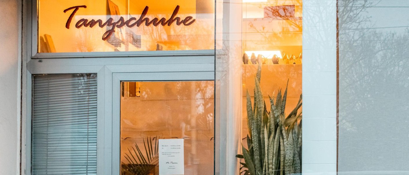 Entrance of a store with the lettering 'Tanzschuhe' above the door. Plants and warm lighting can be seen inside., © SMG, Sarah Schmid Entrance of a store with the lettering 'Tanzschuhe' above the door. Plants and warm lighting can be seen inside., © SMG, Sarah Schmid