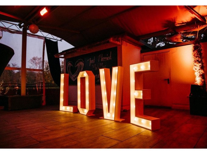 Illuminated letters form the word 'LOVE' in a festively decorated room with warm light., © Cool-Tours StattReisen Illuminated letters form the word 'LOVE' in a festively decorated room with warm light., © Cool-Tours StattReisen