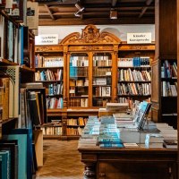 Ein gemütliches Antiquariat mit hohen Bücherregalen und einem Tisch voller Bücher. Im Hintergrund sind kunstvoll verzierte Holzregale zu sehen., © Stuttgart-Marketing GmbH, Sarah Schmid Ein gemütliches Antiquariat mit hohen Bücherregalen und einem Tisch voller Bücher. Im Hintergrund sind kunstvoll verzierte Holzregale zu sehen., © Stuttgart-Marketing GmbH, Sarah Schmid